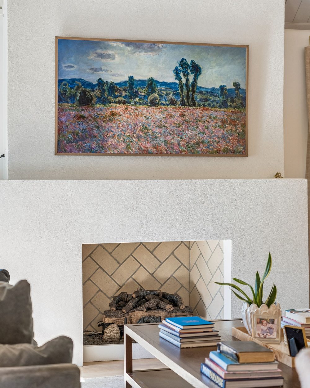 Plaster fireplace with herringbone firebox and framed landscape