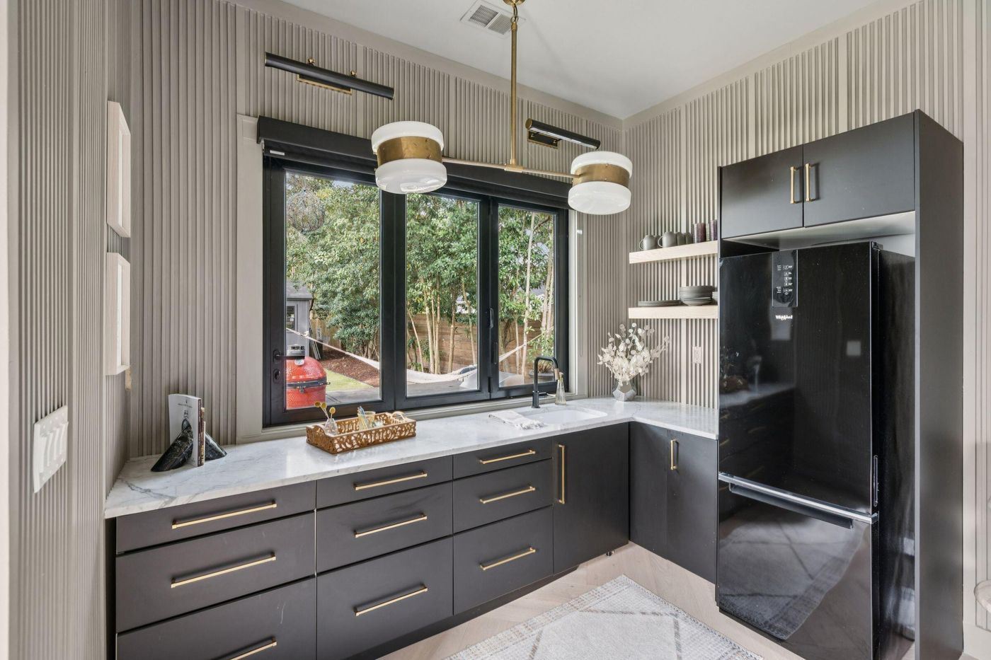 Butler's pantry with fluted walls and brass lighting