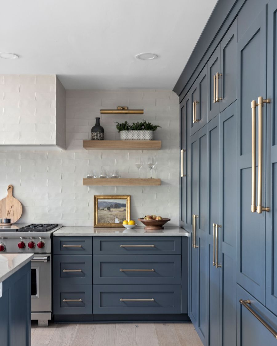 Kitchen with blue cabinetry and brass hardware